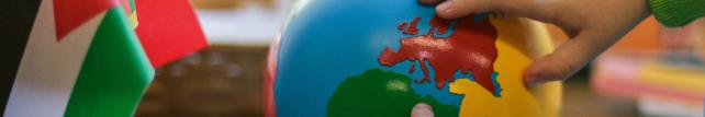 Children pointing at countries on a globe
